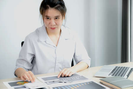 Businesswoman analysis the chart with laptop at the office for setting challenging business goals...