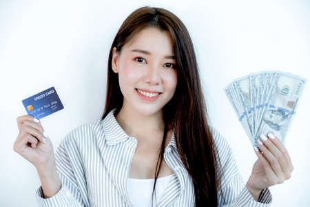 Portrait of a lovely young Asian beautiful woman with long hair holding a blue credit card and...