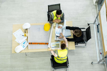Top view of The engineering Team are meeting to inspect the construction drawings, plan work and...