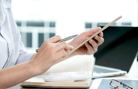 businesswomen bookkeeper use tablet and laptop doing account for paying tax on white desk in working...