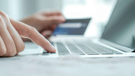 Businesswoman hand use laptop and holding credit card to online shopping from home, payment...