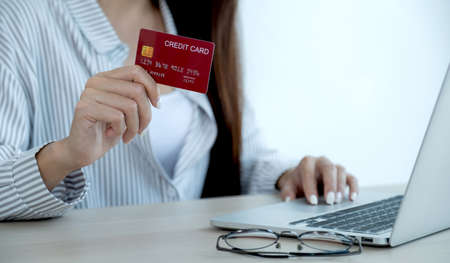 Businesswoman hand holding credit card to online shopping from home, payment e-commerce, internet...