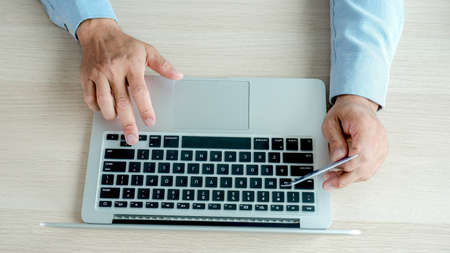 Businesswoman hand use laptop and holding credit card to online shopping from home, payment...