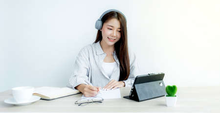 Young Asian teachers are teaching fun online from their home office, social distancing teaching...