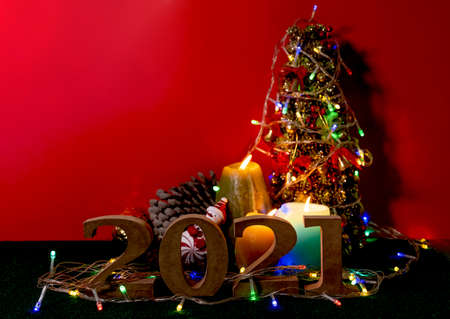 2021 wooden character with Candles lit up with Christmas trees and party lights, the concept of...