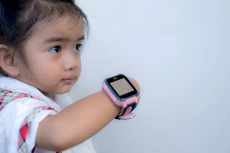 Asian kid use technology smart watches with happy faces.の写真素材