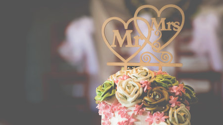 Rose flowers on wedding cake for the bride and groom couple cut in the wedding party event at a restaurant or church.の写真素材