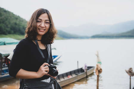 Young Asian tourists spend their free time touring natural lakes. Likes to take pictures as a hobby.の写真素材