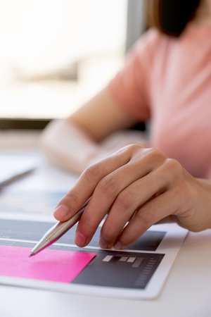 Asia woman hand holding pen, analysis the graph with calculartor and laptop at the home office for setting challenging business goals And planning to achieve the new target.の写真素材