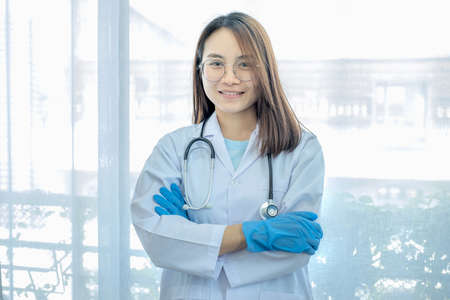 The doctor stood with his arms crossed over the stethoscope on his neck. Eyesight looking at the camera.の写真素材