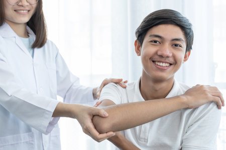 Male patient doing shoulder physical therapy by a female doctor.の写真素材