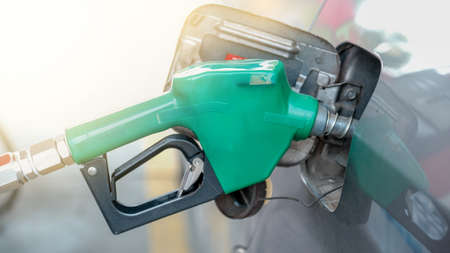 Green nozzle pump Gun petrol from oil pump in the car tank to refueling.