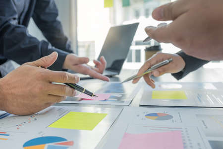 hand holding pen, businesswomen and businessmen team meeting to plan strategies to increase business...