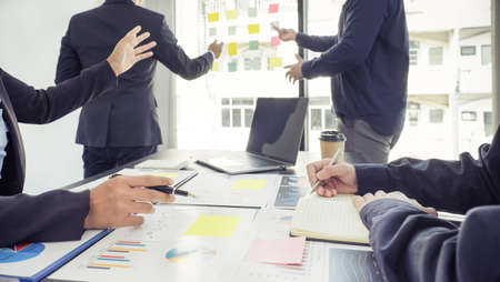 hand holding pen, businesswomen and businessmen team meeting to plan strategies to increase business...