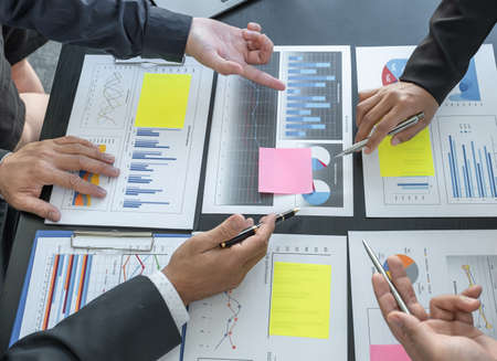 hand holding pen, businesswomen and businessmen team meeting to plan strategies to increase business...