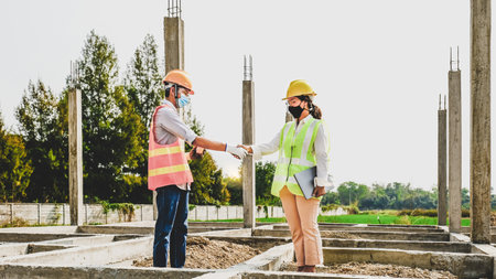 Engineer contractor team hand shake after meeting work safety plan industry project and check design at the construction building siteの写真素材