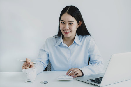 Businesswoman putting coin into piggy bank, step up start up business to success, Saving money for future plan and retirement fund concept.の写真素材
