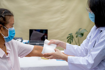 The doctor's is making a wound on the arm of an elderly woman who has an accident.の写真素材
