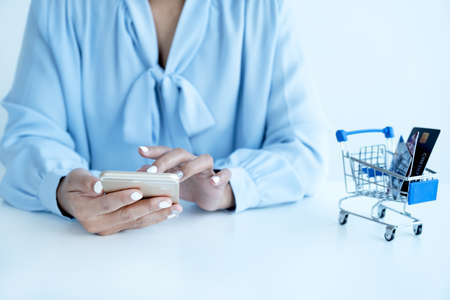 Consumer woman hand use smart phone and a mock up credit card, ready to spending pay online finance...