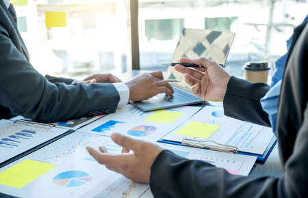 hand holding pen, businesswomen and businessmen team meeting to plan strategies to increase business...