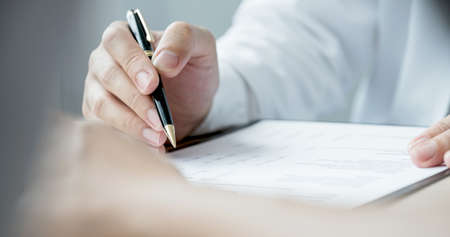 The doctor hand write report and explained examination results to the patient man, healthcare and...