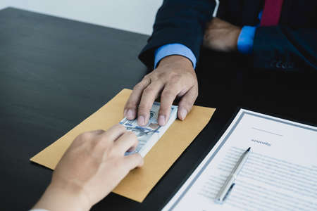 Government officials hand receiving bribe money from businessman, the concept of corruption and anti-bribery.の写真素材