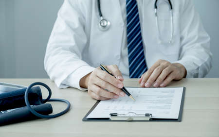 The doctor hand pointing at the health examination report, healthcare and medical checkup concept.