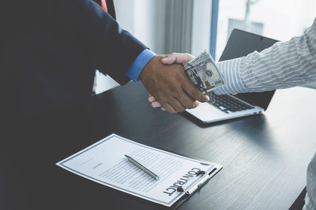 Government officials hand receiving bribe money from businessman in shaking hands, the concept of corruption and anti-bribery.の写真素材