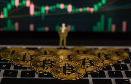 Bitcoin businessman toy and stock exchange graph background. Risk and wealth can happen in investment savings or trading in cryptocurrency innovation.の写真素材