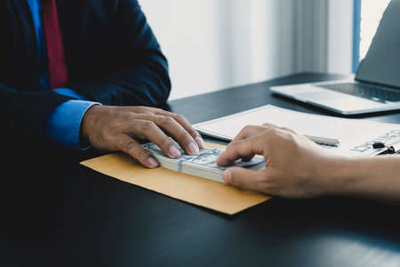 Government officials hand receiving bribe money from businessman, the concept of corruption and anti-bribery.の写真素材