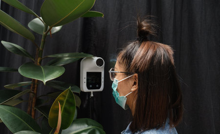 The Asian tourist woman has checked body temperature with a thermal Temperature scanner detector, new normal and travel safety concept.の写真素材