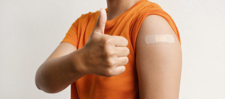Asia woman show shoulder with bandage and hand make thumbs upの写真素材