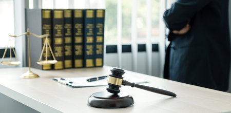 Gavel hammer, The woman lawyer is standing at the desk in the office with a justice scale. Study the law in business disputes to give advice to customers.の写真素材