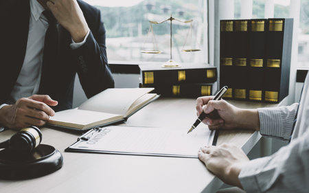 Businessman hand sign contract after lawyer providing legal consult dispute.の写真素材