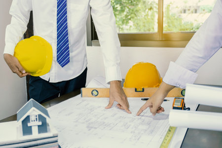 engineers hand pointing to housing plan, contractors meetings for projects, industry, work safety plans and design review.の写真素材