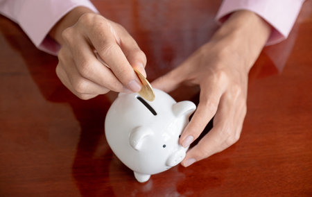 Businessman hand putting bitcoins into white piggybank. risk and wealth can happen in investment savings or trading in cryptocurrency innovationの写真素材