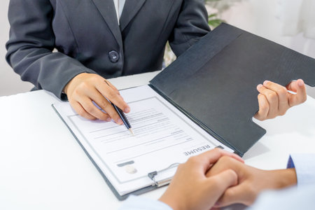 Office executives hand holding pen and interviewing job applicants in the meeting room. employer conversation summary work employment.の写真素材