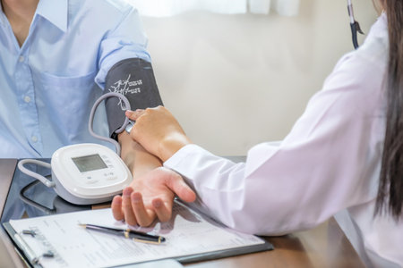 Doctor hand examines the patient's pulse with stethoscope and records the results, health medical checkup concept.の写真素材