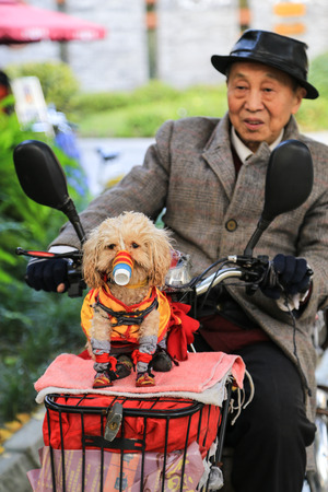 An old man with dog in funny costume at Chengdu, Chinaのeditorial素材