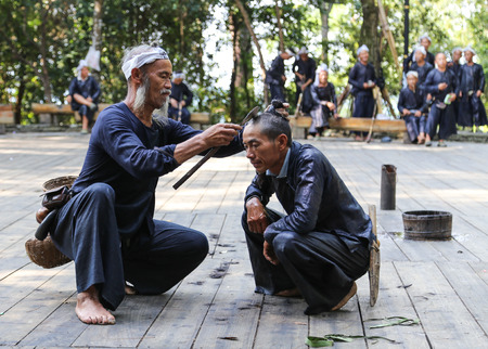 Sickle haircut in basha miao village,guinzhou,chinaのeditorial素材
