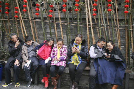 people playing mobile phone in a park,chengdu,chinaのeditorial素材
