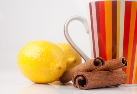 cup with two lemons and cinnamon on whiteの写真素材