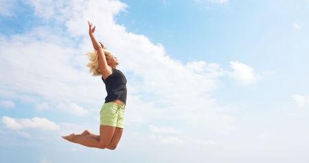 blonde girl jumping high outdoor in nature