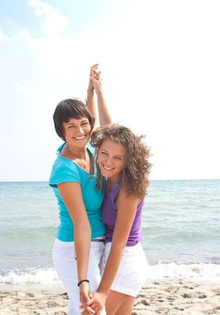 two happy girls having fun on the beachの写真素材