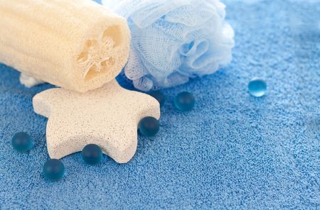 foot stone, sponge and loofah on blue towelの写真素材