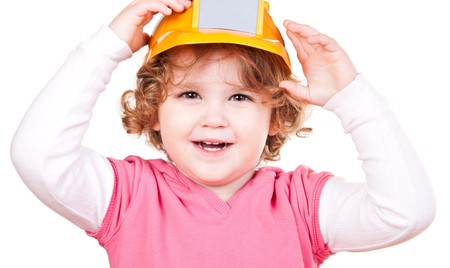happy little girl with yellow helmet on her headの写真素材