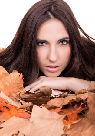 pretty brunette girl in autumn leaves isolated on whiteの写真素材