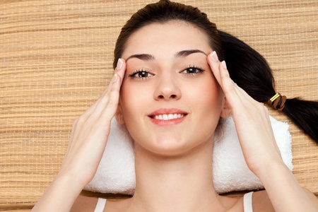 woman massage her head in massage studio, close upの写真素材