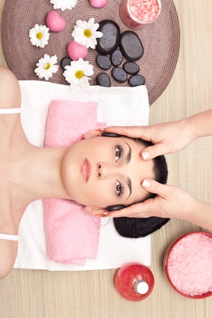 young relaxed woman receiving a head massage at spa centerの写真素材