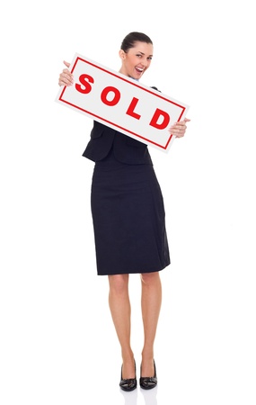 real estate agent or businesswoman holding sold sign , isolated on white background, full lengthの写真素材